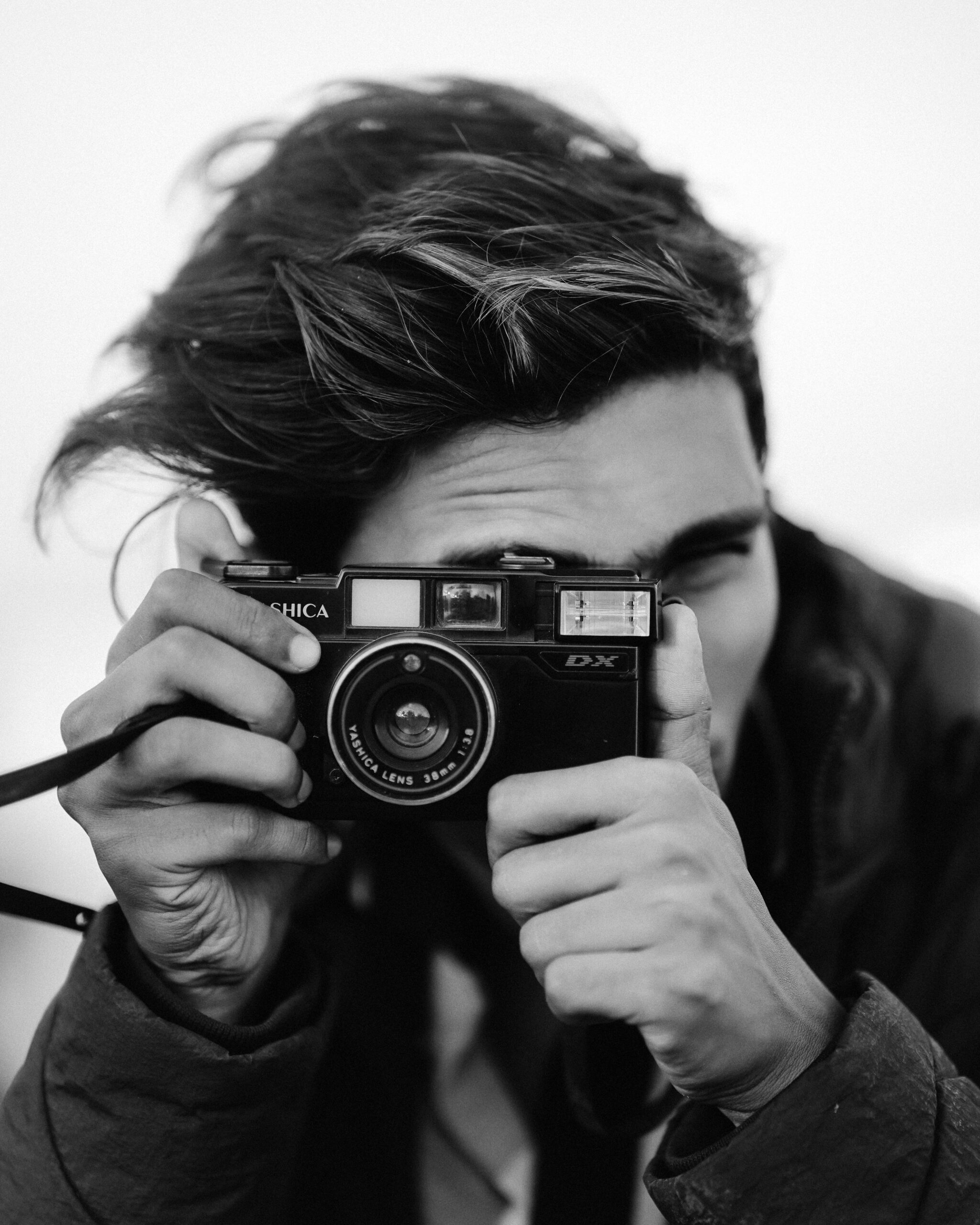 image of a man holding a small film camera